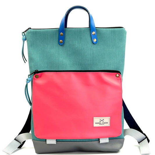 parte delantera de la mochila book holder de colores turquesa, rosa y gris de daniel chong