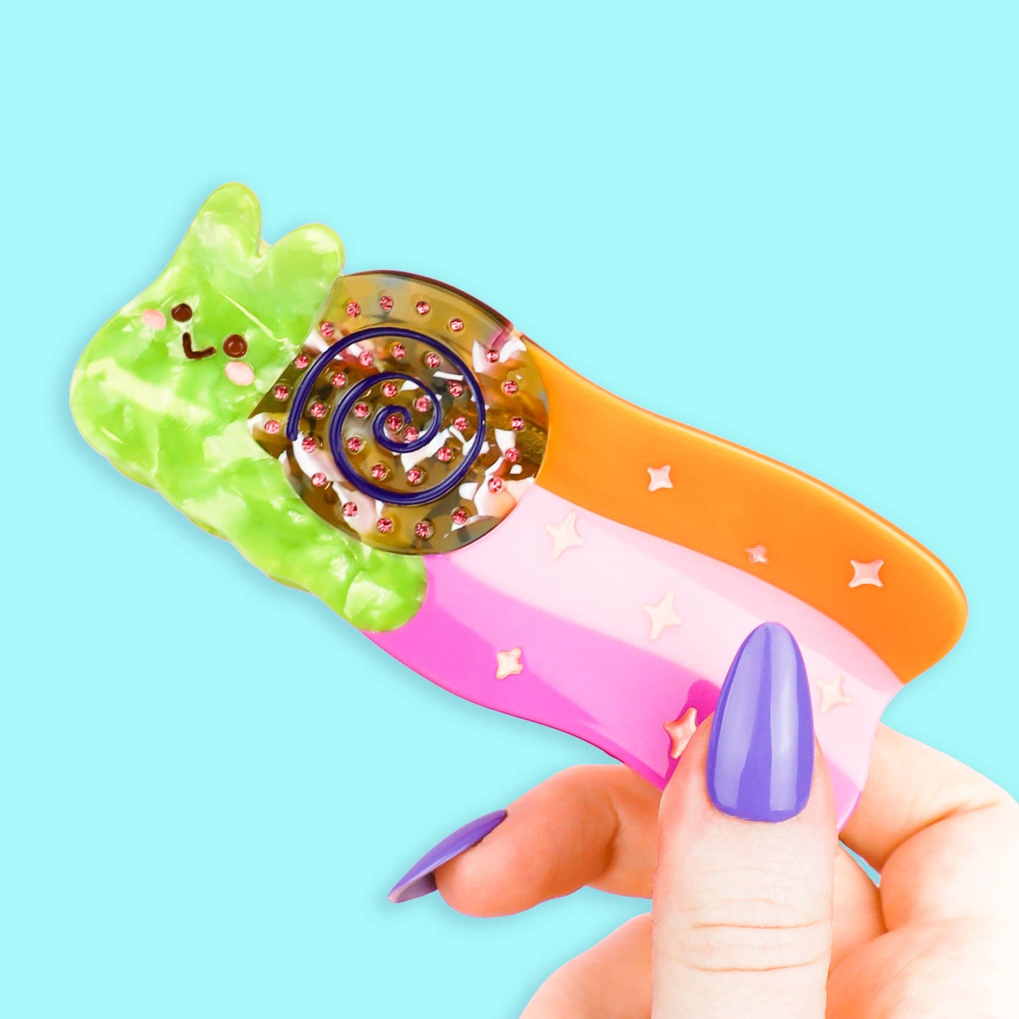Pinza para el pelo de colores con forma de caracol dejando rastro de arcoiris