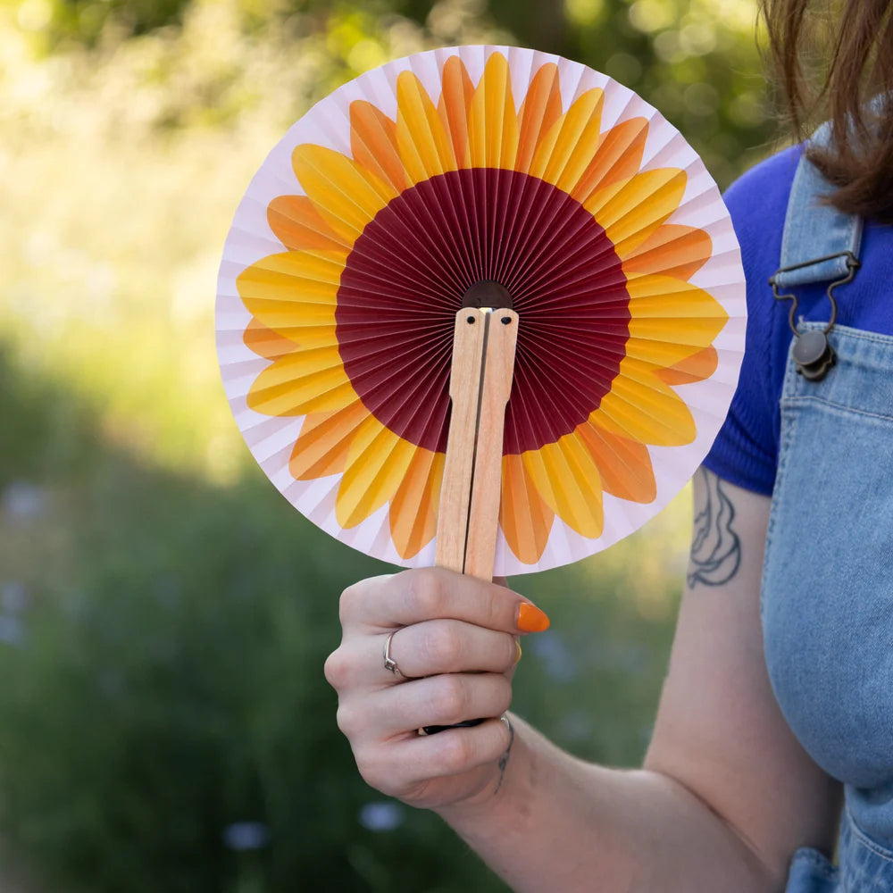 persona sujetando el pai pai abierto con un dibujo de un girasol