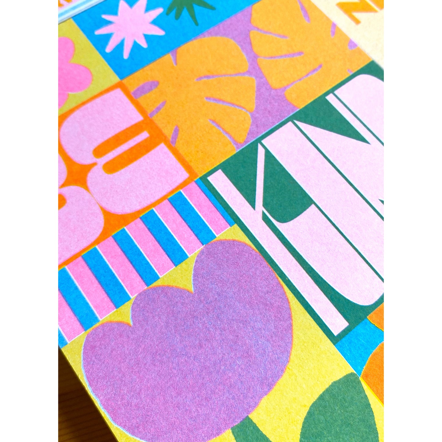 Detalle de la mini print de colores con flores, hojas, estrellas y el mensaje BE KIND