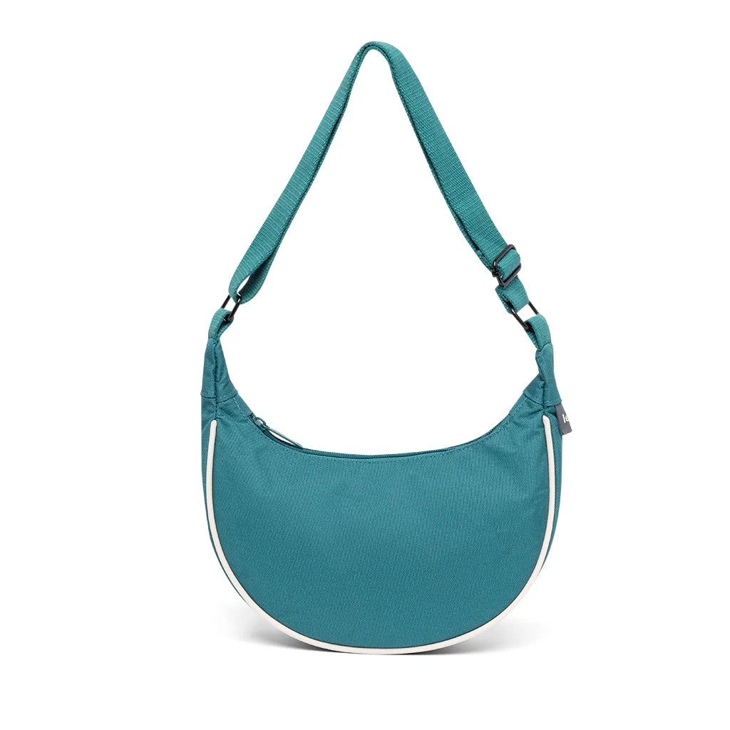 Bolso rosa turquesa con un ribete blanco en forma de media luna para llevar al hombro o en bandolera de la marca Lefrik