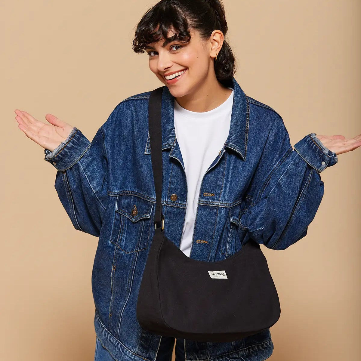 Mujer con cazadora vaquera y bolso de bandolera en color negro hecho de algodón orgánico de la marca francesa Hindbag