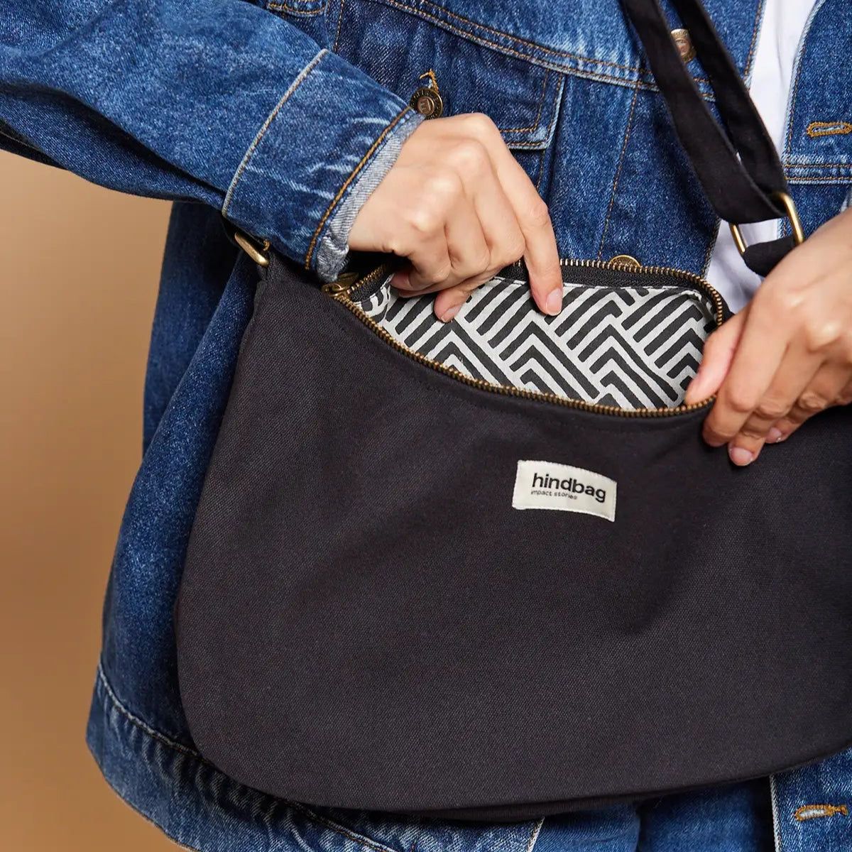 Mujer con bolso de hombro en color negro y forro estampado hecho de algodón orgánico de la marca francesa Hindbag
