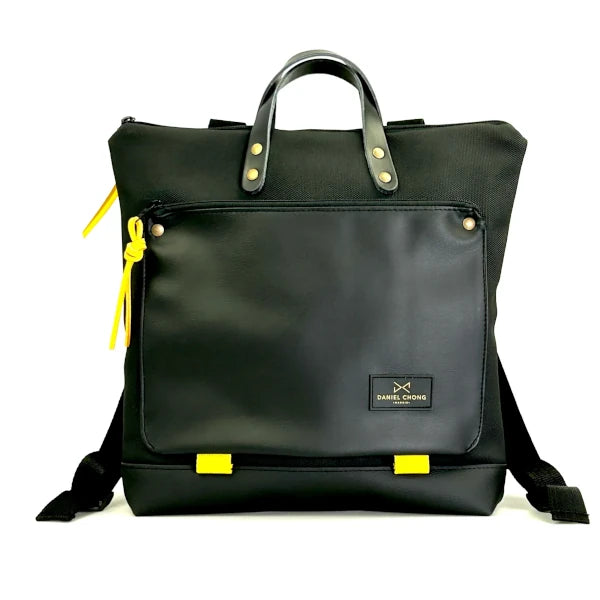 Mochila cuadrada e impermeable negra con detalles en amarillo diseñada por Daniel Chong