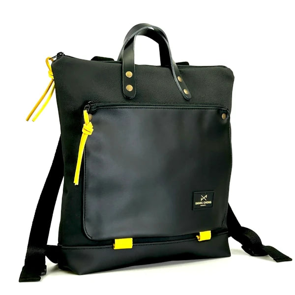 Mochila cuadrada e impermeable negra con detalles en amarillo diseñada por Daniel Chong