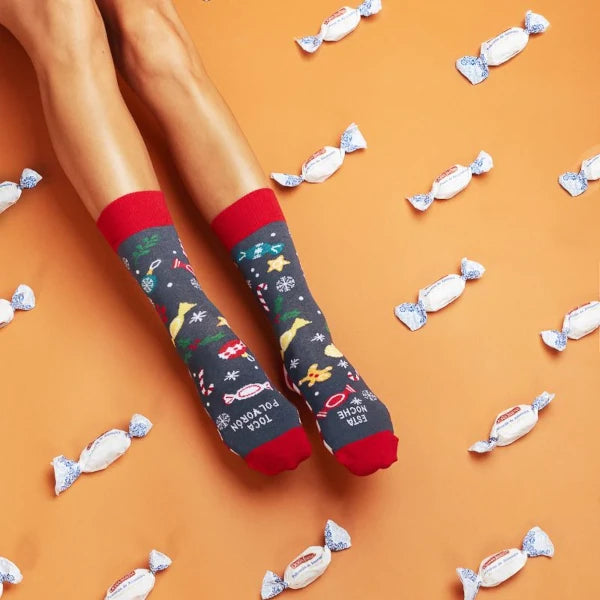 Piernas con caletines con estampado de Navidad y rodeadas de polvorones