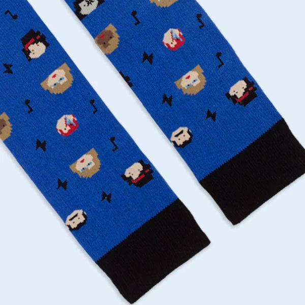 Detalle de la parte de arriba de los calcetines de media caña zules con el mensaje Eres un temazo y estampado de rayos, notas musicales y caras de iconos de la música
