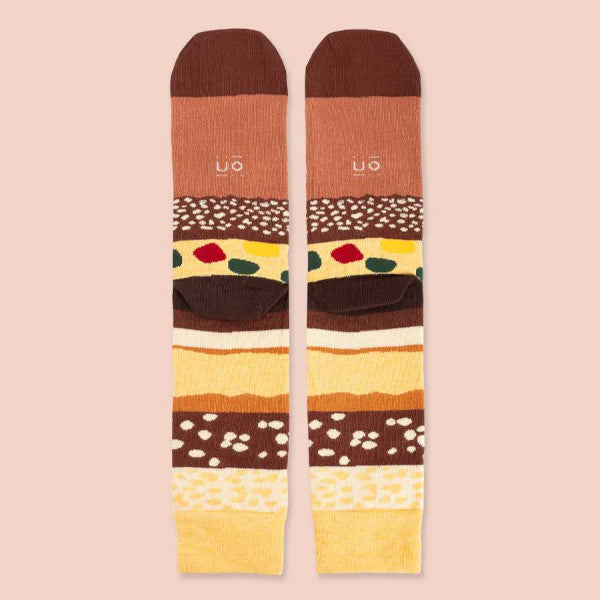 Parte trasera de los calcetines de Navidad estampados de capas de chocolate, almendra, fruta escarchada, almendrado, turrón blando y el mensaje "Estás mejor que el turrón"