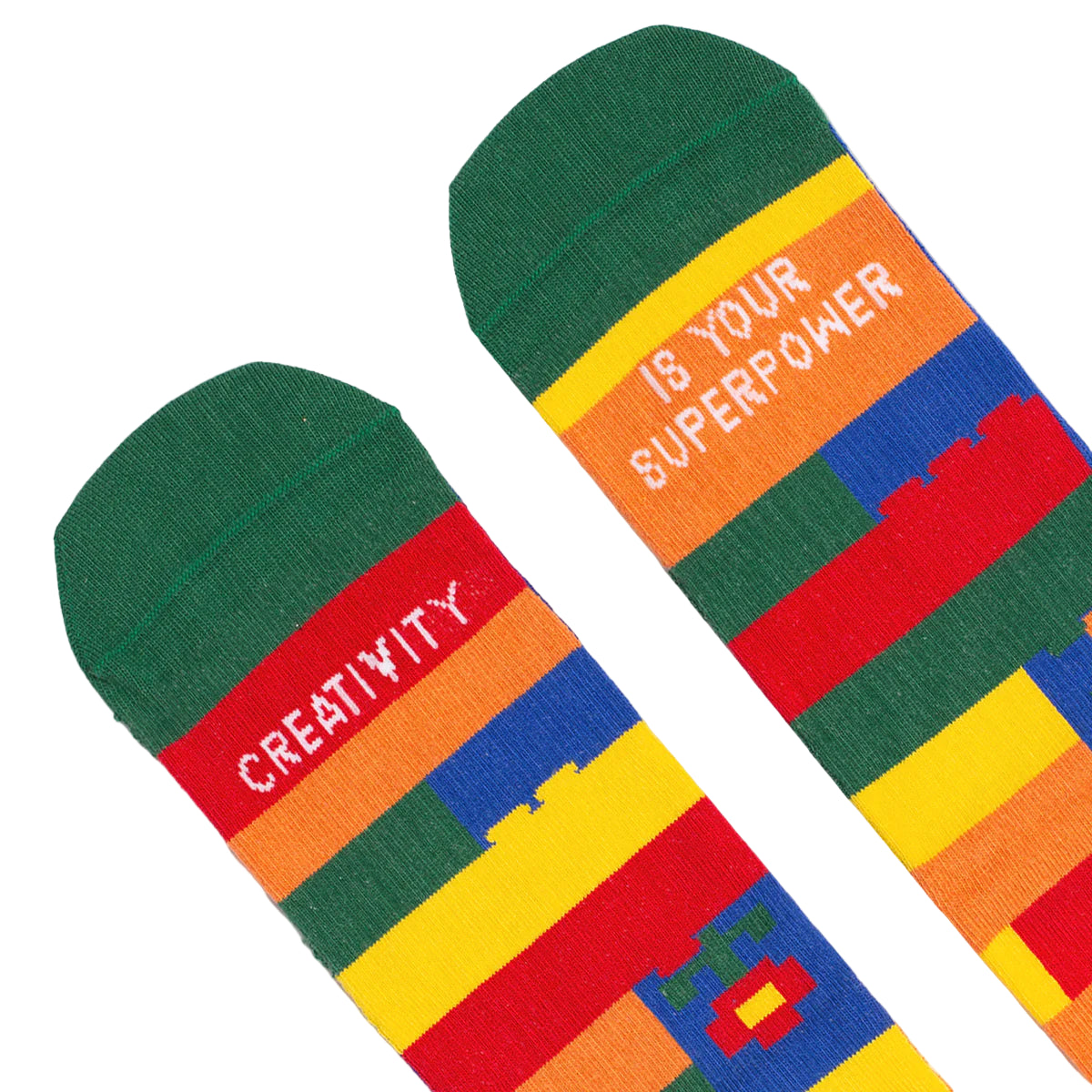 detalle de los calcetines de colores con puntera verde y el mensaje "Creativity / is your superpower" escrito en cada pie