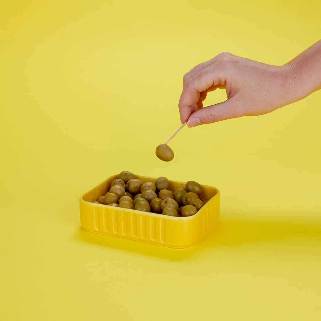 Cuenco de cerámica amarillo para aperitivo con forma de lata de sardinas lleno de aceitunas