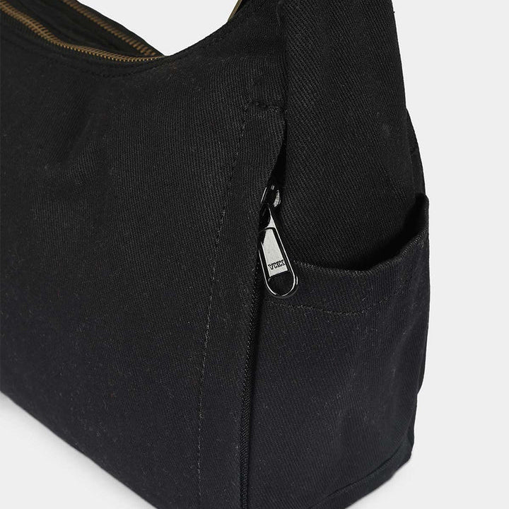 parte lateral del bolso Emile en negro donde se ven los bolsillos laterales.