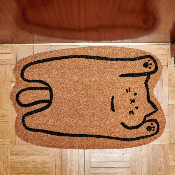 Felpudo con forma de gato panza arriba en un umbral