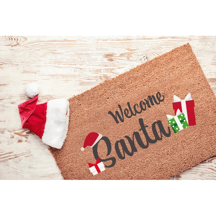 Felpudo de entrada con el mensaje Welcome Santa, regalos y un gorro de Papá Noel
