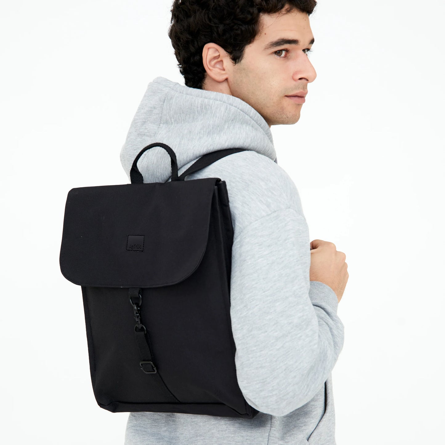 Chico con sudadera llevando la mochila reciclada e impermeable Handy mini de Lefrik en color negro