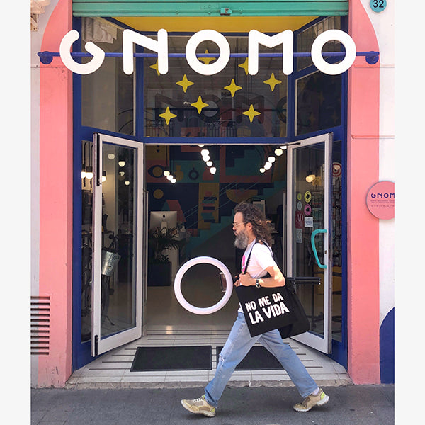 Álvaro pasando por la puerda de gnomo, cargado con un aro de luz y la tote bag negra no me da la vida