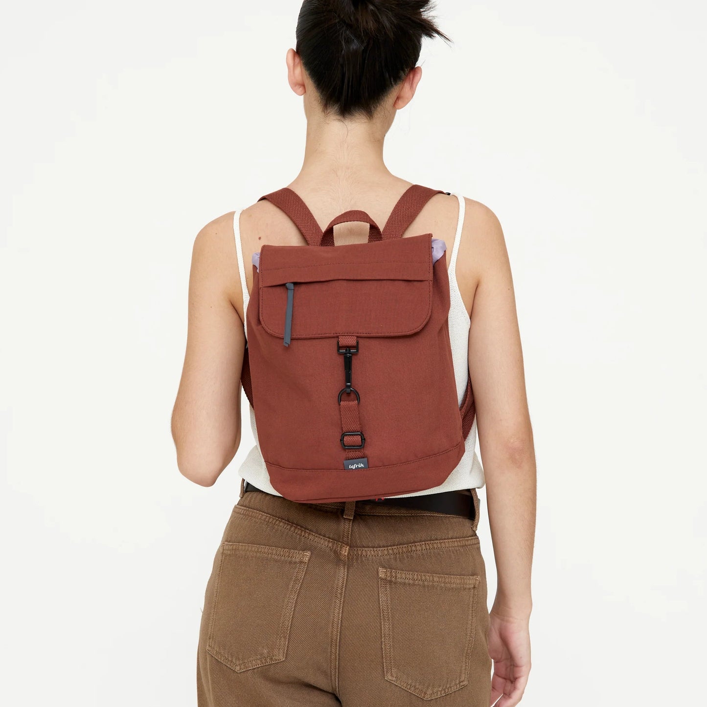 chica de espaldas posando con la mochila mini scout arles de lefrik puesta, en color teja bronze