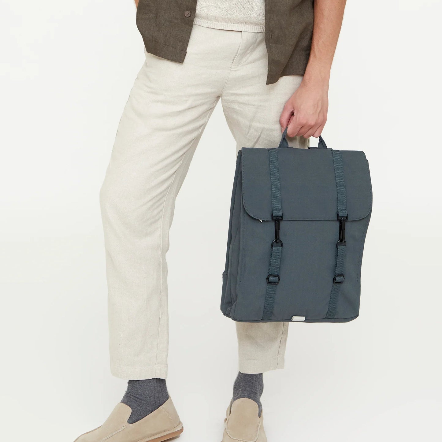 modelo con la mochila handy de lefrik color hoja de laurel cogida por el asa superior