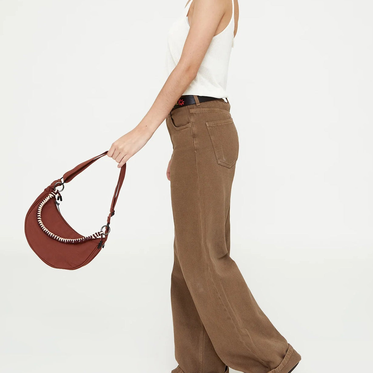 persona balanceando el bolso lua en color bronze de lefrik