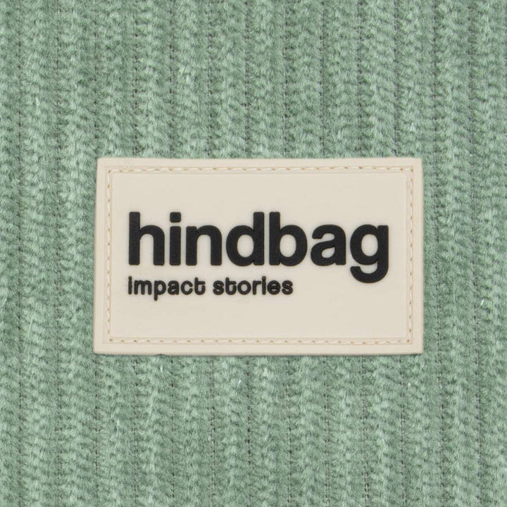 Tejido de pana verde y etiqueta de la marca Hindbag