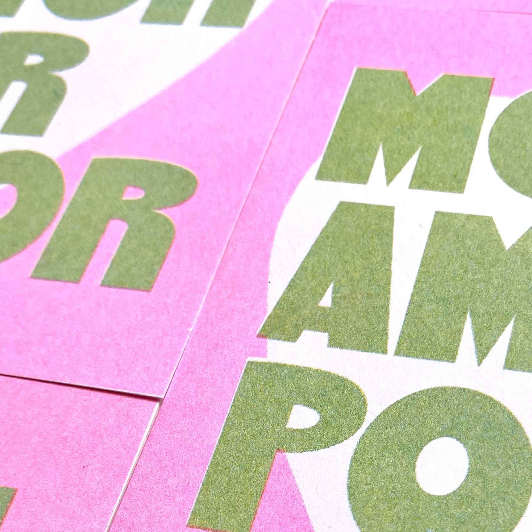 Tarjeta en risografía en verdes y rosas con el mensaje More amor por favor