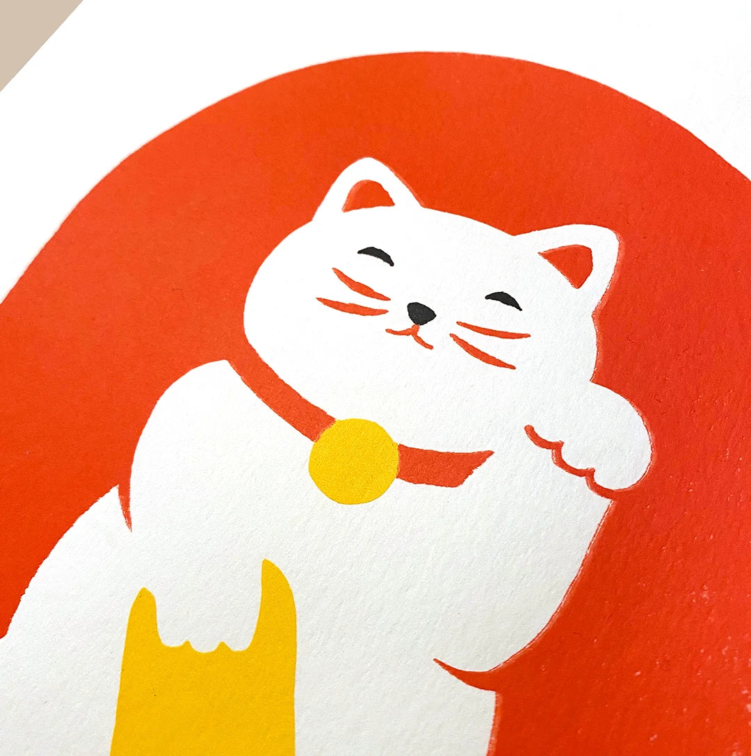 Detalle del Maneki Neko blanco sobre fondo rojo.