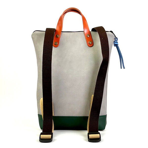 Parte de atrás con correas negras de algodón de la mochila pequeña sostenible de Daniel Chong en color gris con bolsillo delantero de cuero naranja