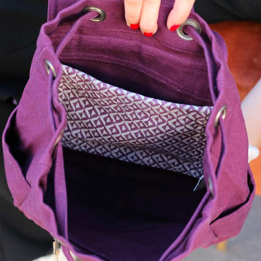 Mochila de tela fuerte pequeña color ciruela de la marca francesa Hindbag abierta con bolsillo estampado en el interior