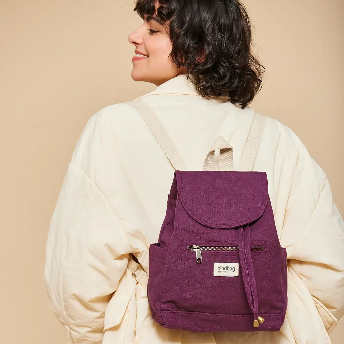 Chica de espaldas con la Mochila de tela fuerte pequeña color ciruela de la marca francesa Hindbag
