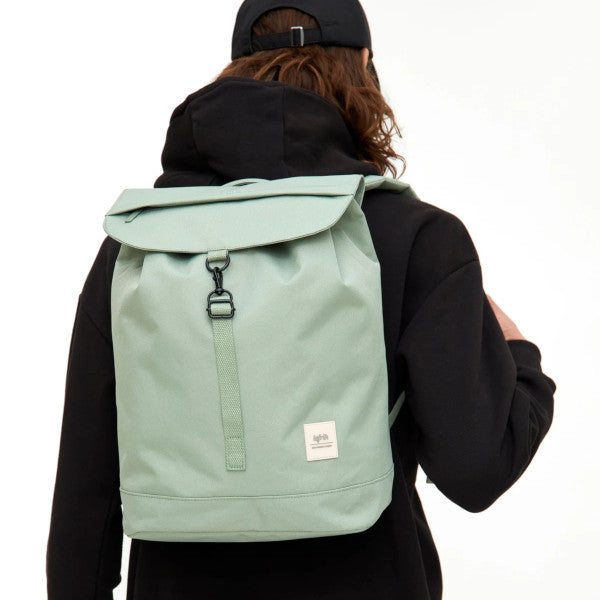 Chico de espaldas con sudadera y gorra negras y la mochila color verde salvia de Lefrik al hombro