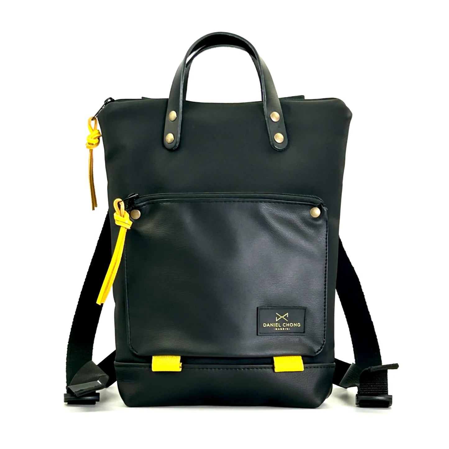 Mochila impermeable negra con detalles en las cremalleras amarillos. Con bolsillo para sujetar un libro, asas de piel, fabricada en España de Daniel Chong.
