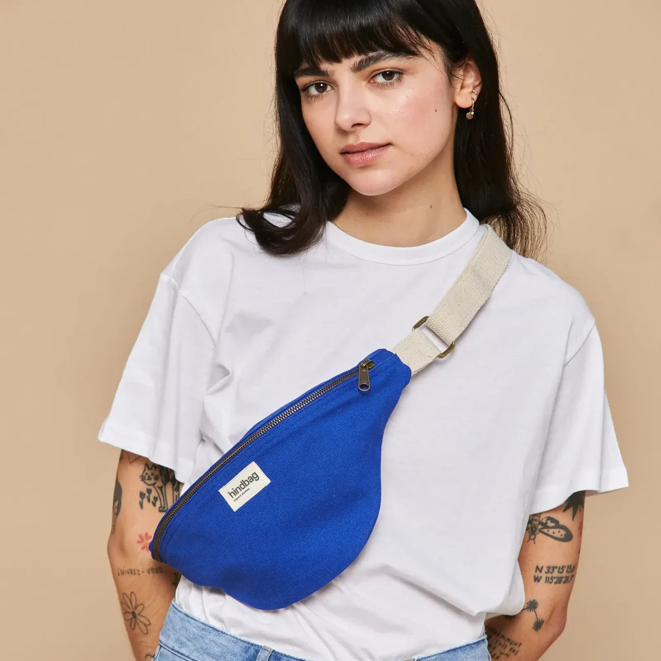 Mujer con camiseta blanca y la riñonera de algodón orgánico en color azul eléctrico de la marca francesa Hindbag
