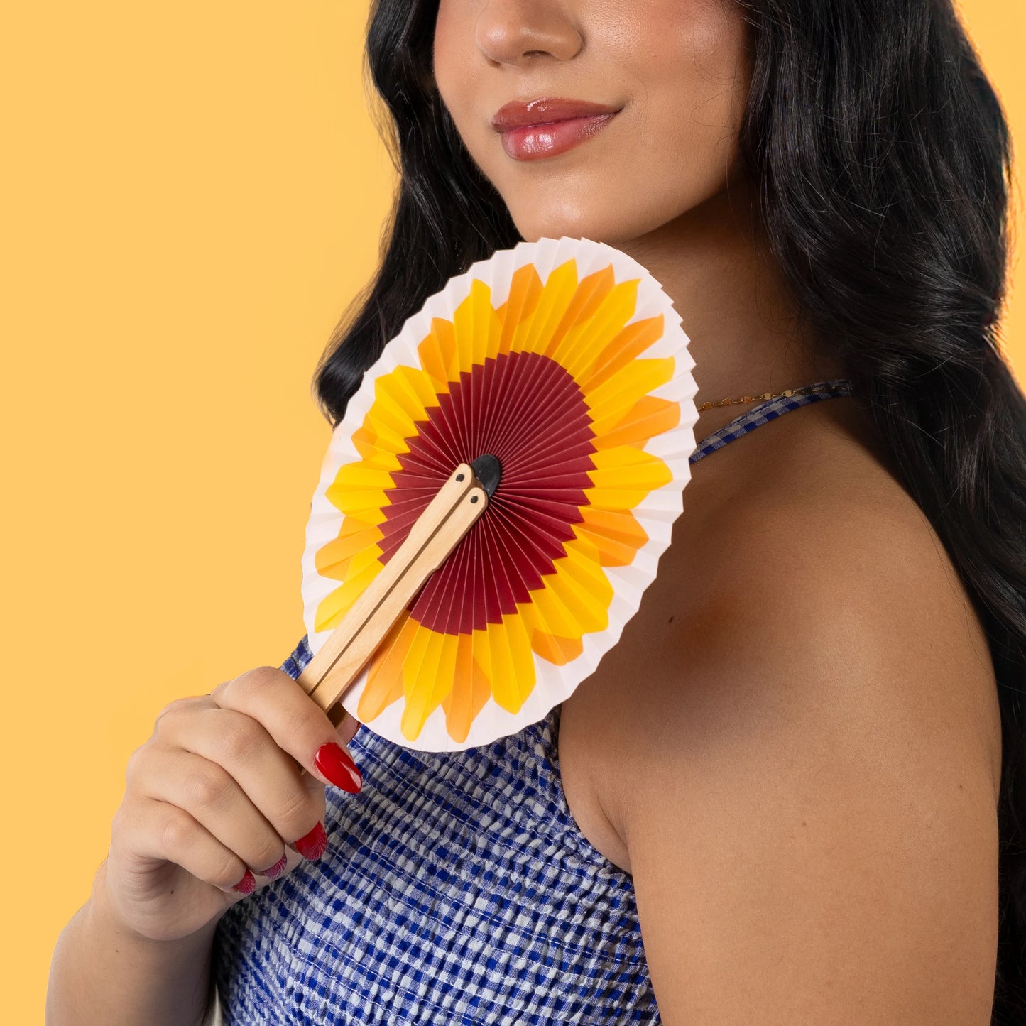 chica sujetando un pai pai por fisura con estampado de girasol