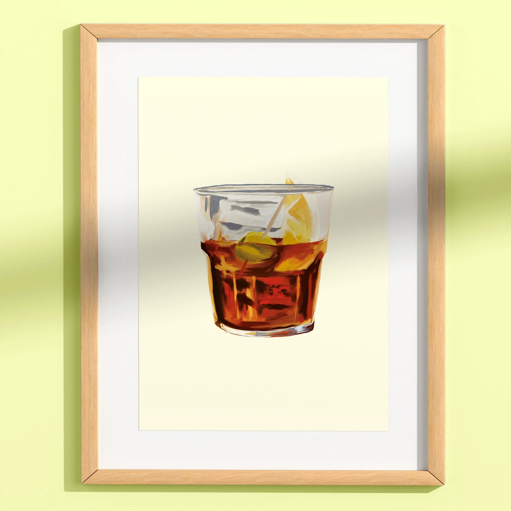 print enmarcada de la ilustradora Laura Ortiz de un vaso de vermout rojo con una oliva y una rodaja de limón, en un marco de madera, con passepartout blanco y colocado en una pared de color verde