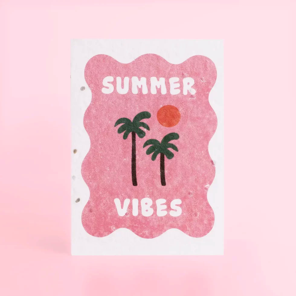 postal con semillas dentro de la marca resetea con un cuadraro en color rosa con dos palmeras y un sol y el texto Summer Vibes en blanco