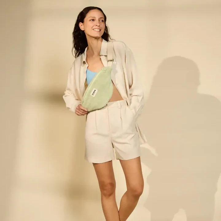 Mujer con riñonera verde de rizo de la marca hindbag