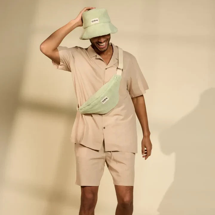 Hombre con gorro y riñonera verde de rizo de la marca hindbag
