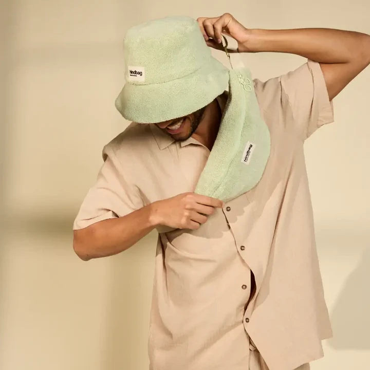 Hombre con gorro y riñonera verde de rizo de la marca hindbag