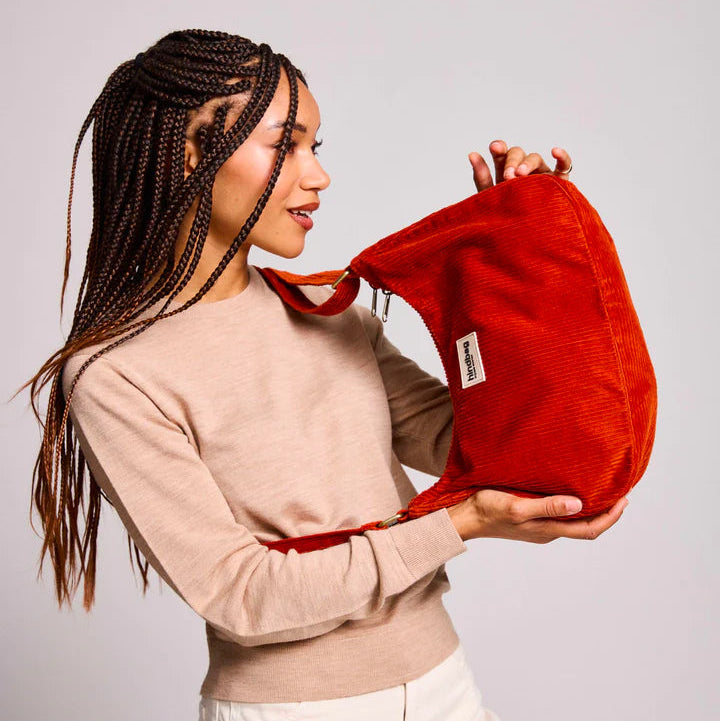 Mujer con bolso de pana de color rojo ladrillo colgado al hombro