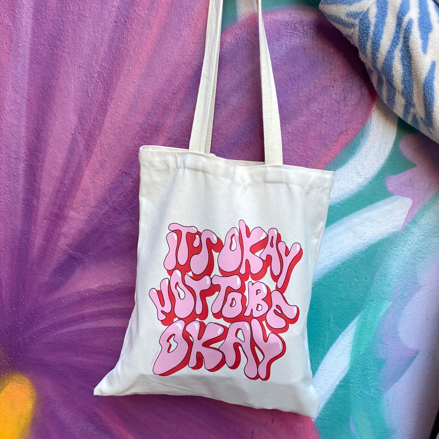 foto de la tote de Laura Ortiz con el texto "it's okay not to be okay" en rosa