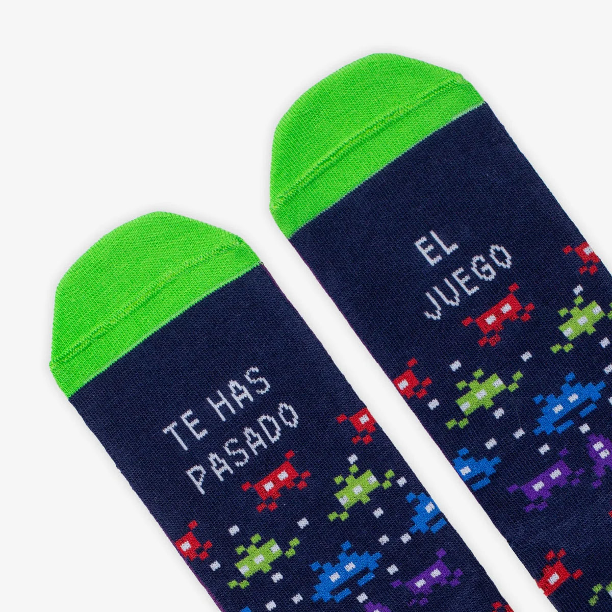 Detalle de la puntera verde de los calcetines con estampado de Space Invaders y la frase Te has pasado / el juego en cada pie