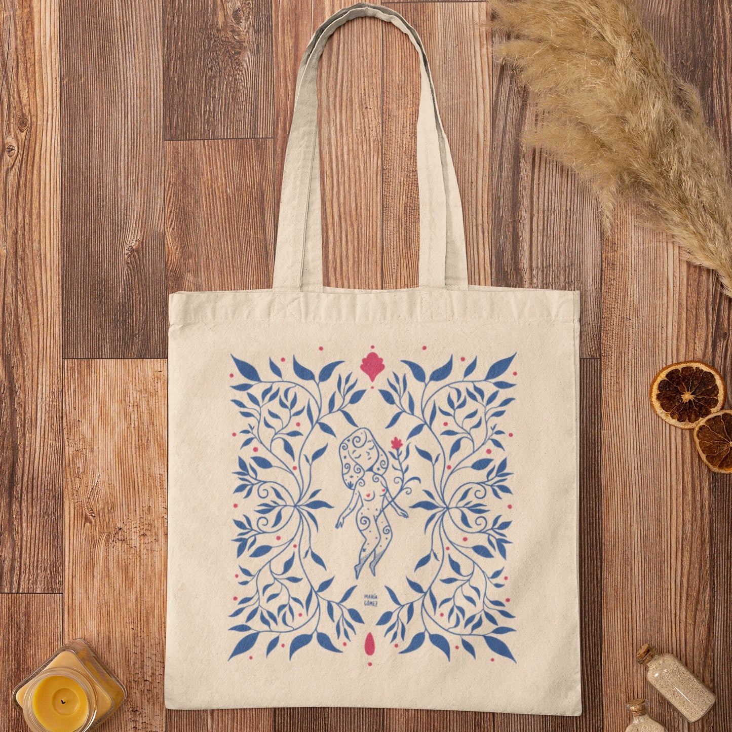 Bolsa de tela con una mujer flotando entre flores azules de María Gómez sobre un suelo de madera