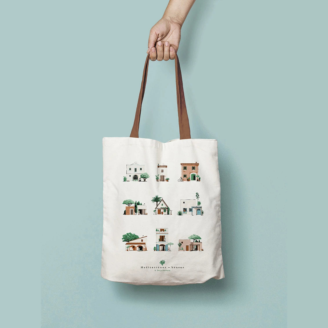 bolsa de tela con un diseño de Borja Bonaque con una ilustacion de nueve casas con arquitectura en estilo mediterráneo y con las asas de color marrón