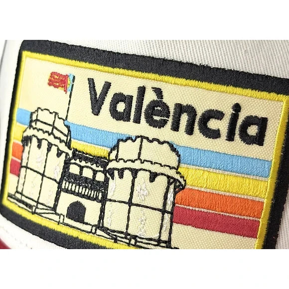 Detalle del parche de la gorra Blanca con visera roja y parche con el texto València y las torres de serrano bordadas