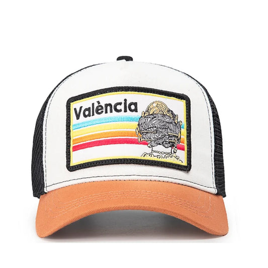 Vista frontal de gorra de Blocals con letras València. Parte delantera color blanco, visera naranja. Contiene también la imagen del peinado de una fallera.