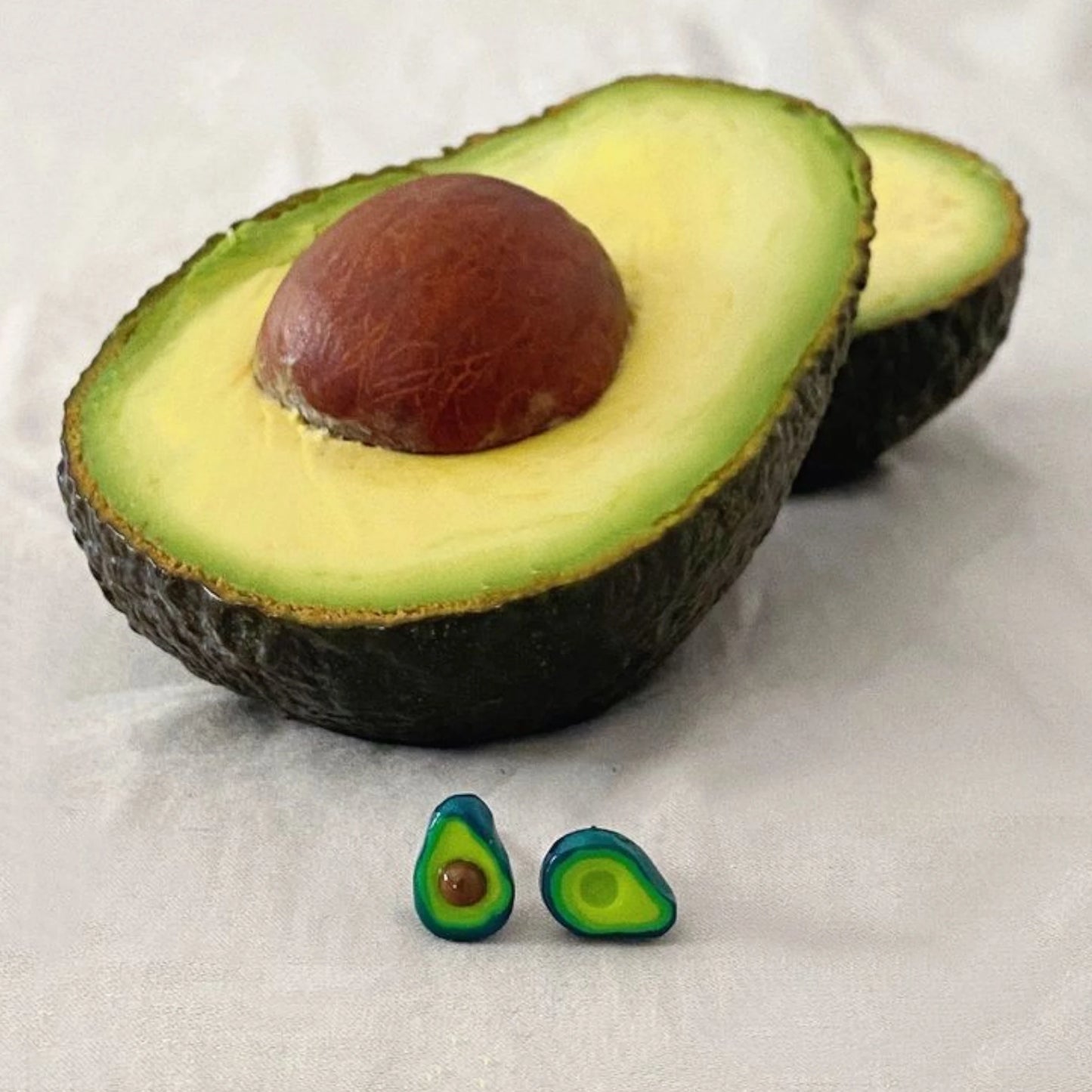 foto de un aguacate partido por la mitad con los pendientes en forma de aguacate de natsuokamu