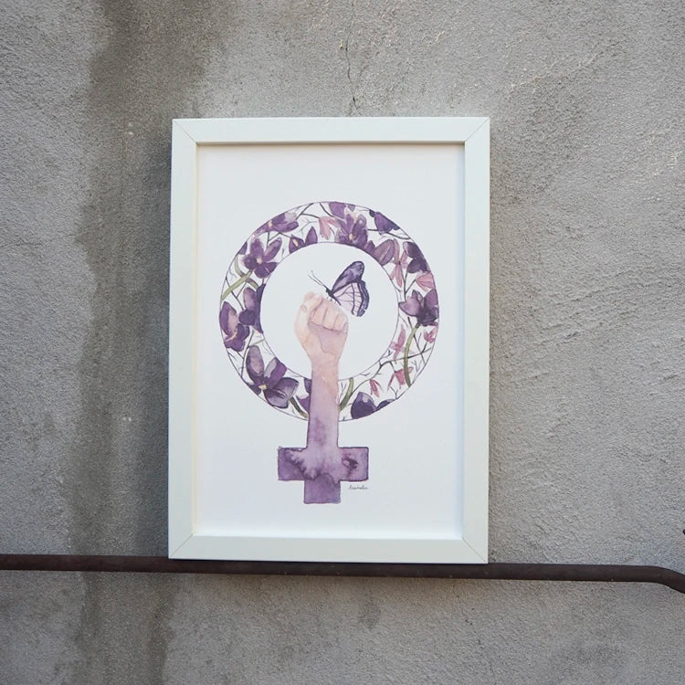 lámina feminista del 8M con el símbolo de la mujer y un puño con una mariposa posada, con el fondo de flores moradas. Enmarcado en un cuadro de color blanco