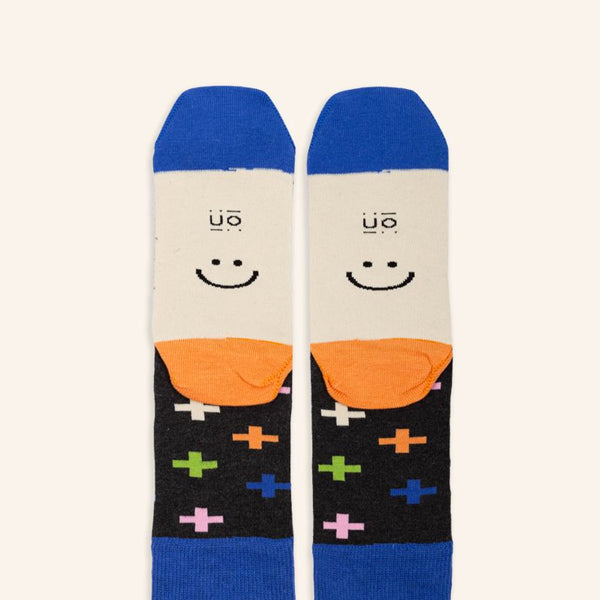 Calcetines eres lo mas negros con signos de suma en varios colores vista de la planta con una carita feliz