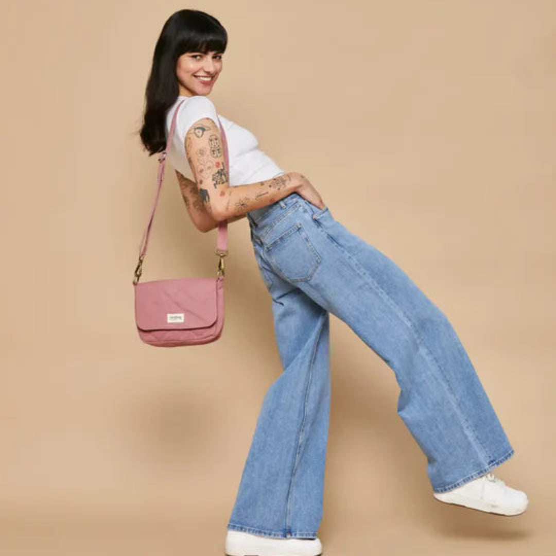 Mujer con vaqueros y camiseta blanca llevando el bolso acolchado pequeño en color rosa de la marca francesa Hindbag