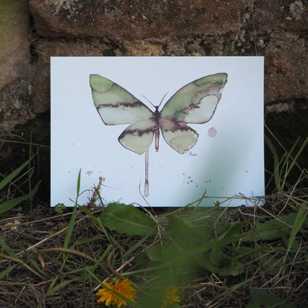 Print de una mariposa Laguna real de Marialu colocada en el césped