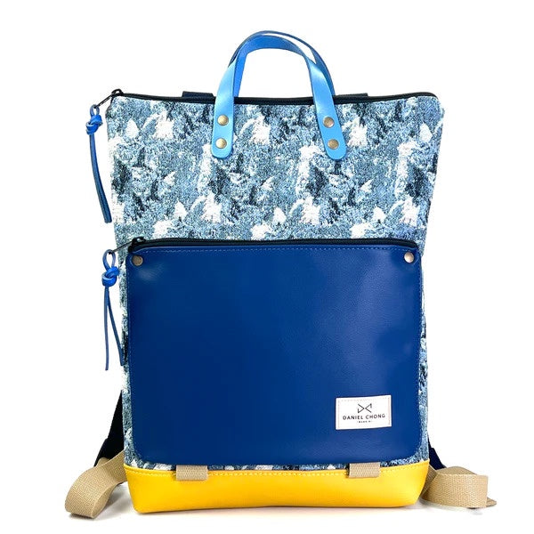 Mochila sostenible de Daniel Chong estampada azul con bolsillo delantero en piel azul oscuro